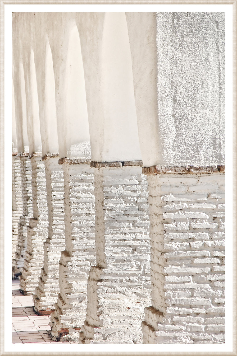 Masonry – Colonnade wall art featuring white arches and textured columns in a light setting.