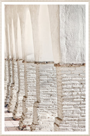 Masonry – Colonnade wall art featuring white arches and textured columns in a light setting.
