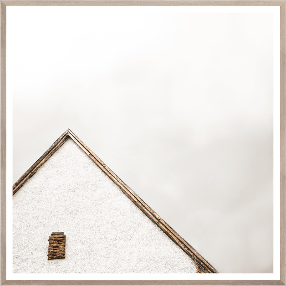 The Peak wall art featuring a minimalist white house roof with wooden accents against a light background.