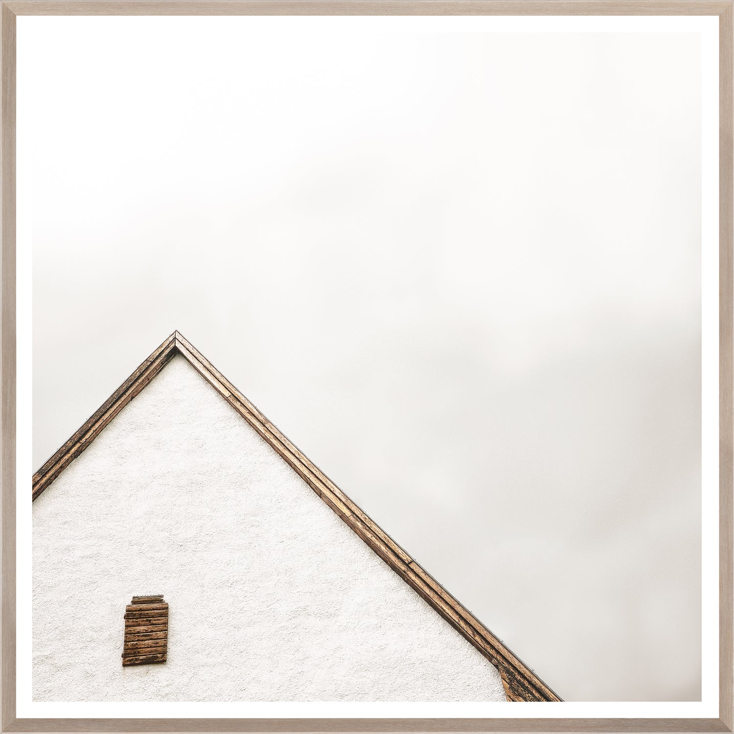 The Peak wall art featuring a minimalist white house roof with wooden accents against a light background.