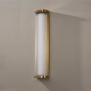Newburgh Bath And Vanity 5.25" x 24.5" in aged brass shown from the front to reveal the arm spread and shade silhouette.