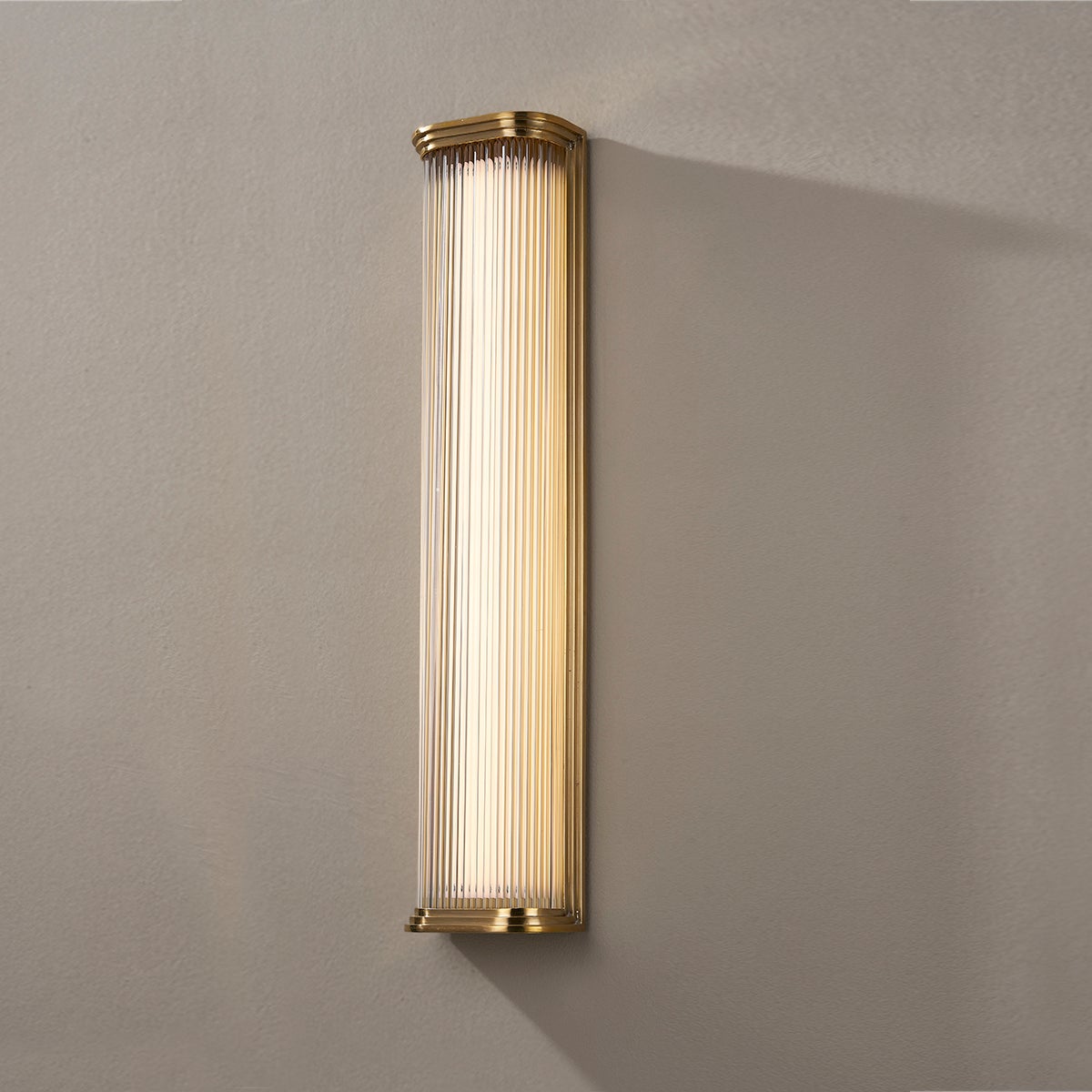 Close-up of the Newburgh Bath And Vanity 5.25" x 24.5" in aged brass showing the arm spread and shade silhouette.