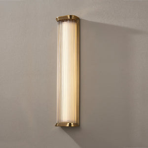 Close-up of the Newburgh Bath And Vanity 5.25" x 24.5" in aged brass showing the arm spread and shade silhouette.