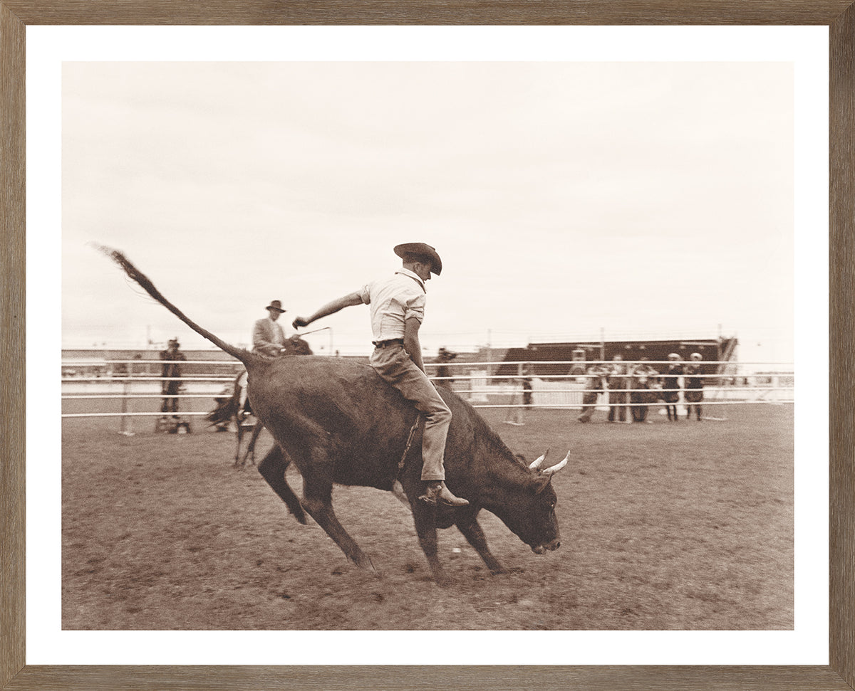 Rodeo II C. 1962 wall art featuring a cowboy riding a bull in sepia tones.