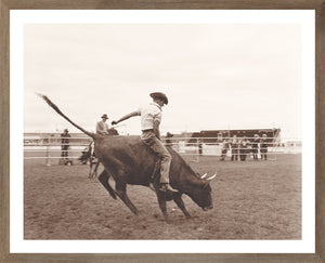Rodeo II C. 1962 wall art featuring a cowboy riding a bull in sepia tones.