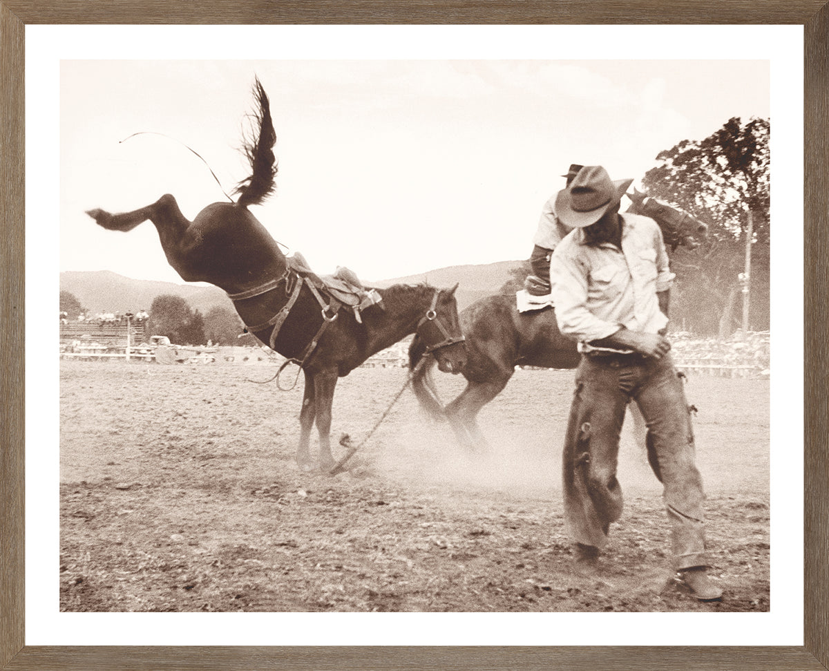 Rodeo III C. 1962 wall art featuring a cowboy riding a bucking horse in sepia tones