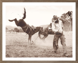 Rodeo III C. 1962 wall art featuring a cowboy riding a bucking horse in sepia tones