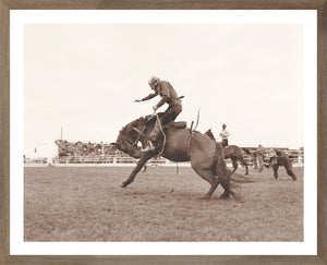 Rodeo IV C. 1962 wall art featuring a cowboy riding a bucking horse in sepia tones.