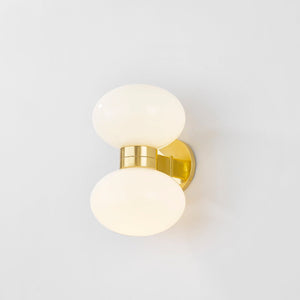 Close-up of the Otsego Wall Sconce in aged brass showing the arm curve and shade silhouette.