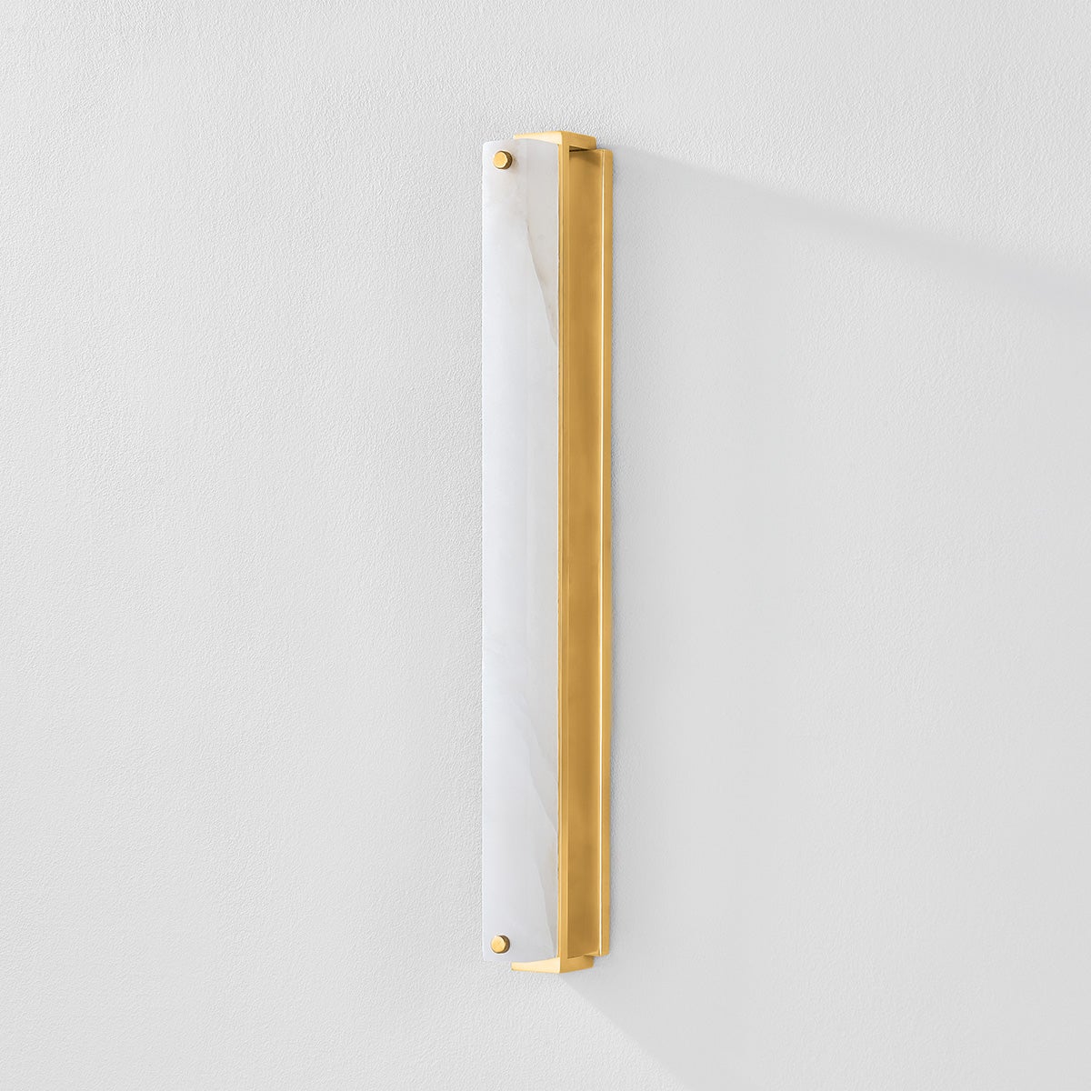 Close-up of the Edgemere Wall Sconce in aged brass showing the arm curve and shade silhouette.
