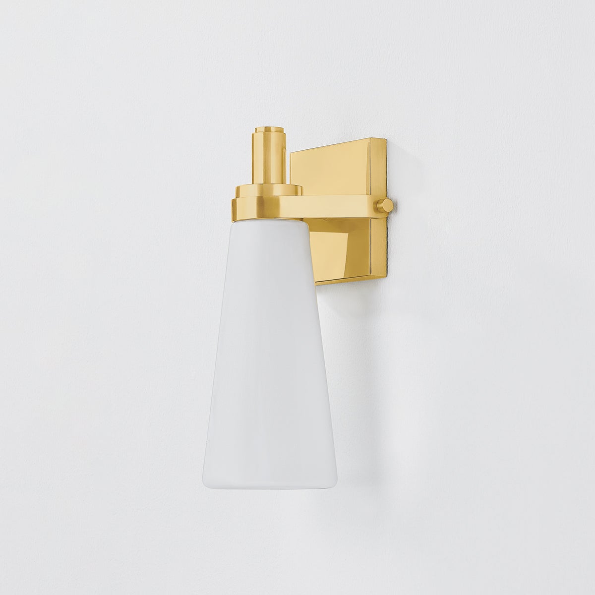 Close-up of the Trude Wall Sconce in aged brass showing the arm curve and shade silhouette.