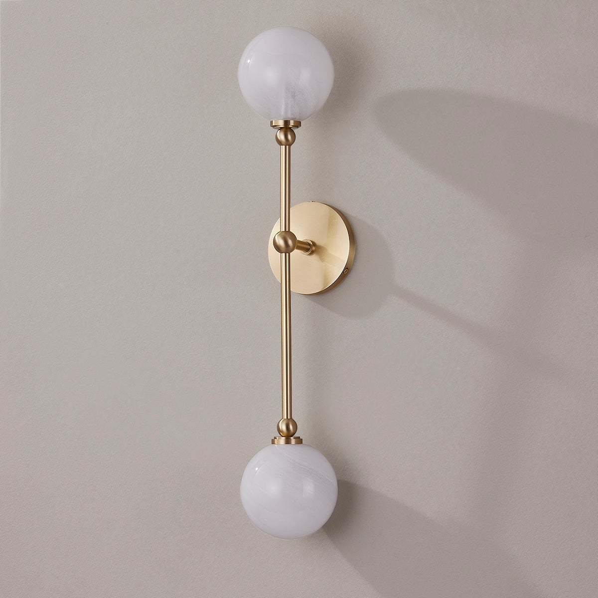 Andrews Wall Sconce in aged brass shown from the front to reveal the arm curve and shade silhouette.
