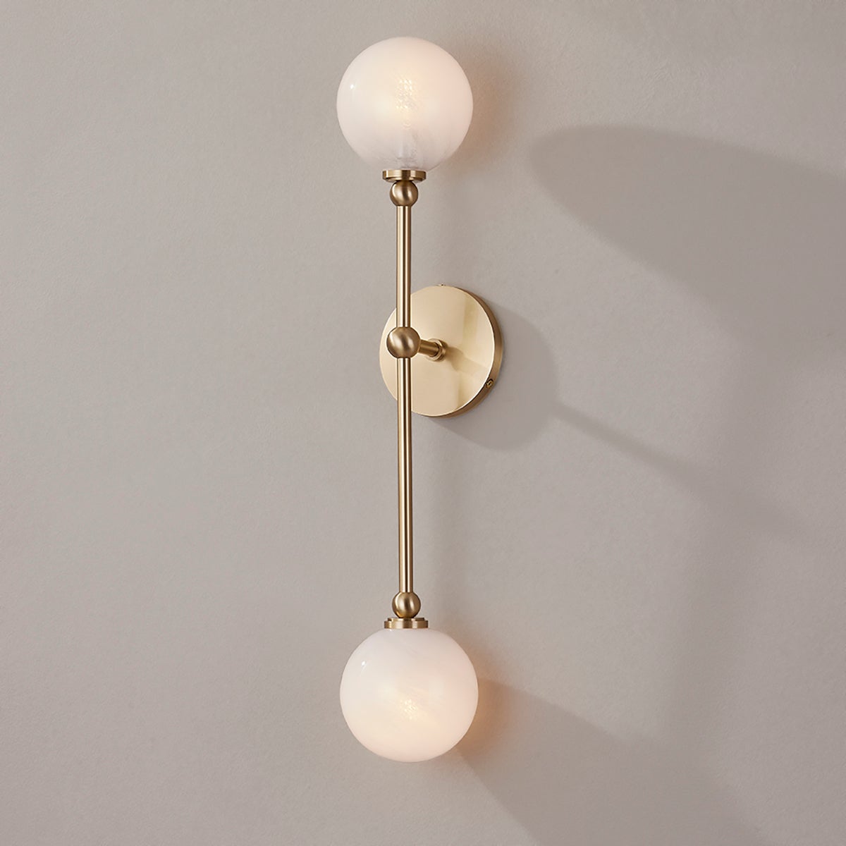 Close-up of the Andrews Wall Sconce in aged brass showing the arm curve and shade silhouette.
