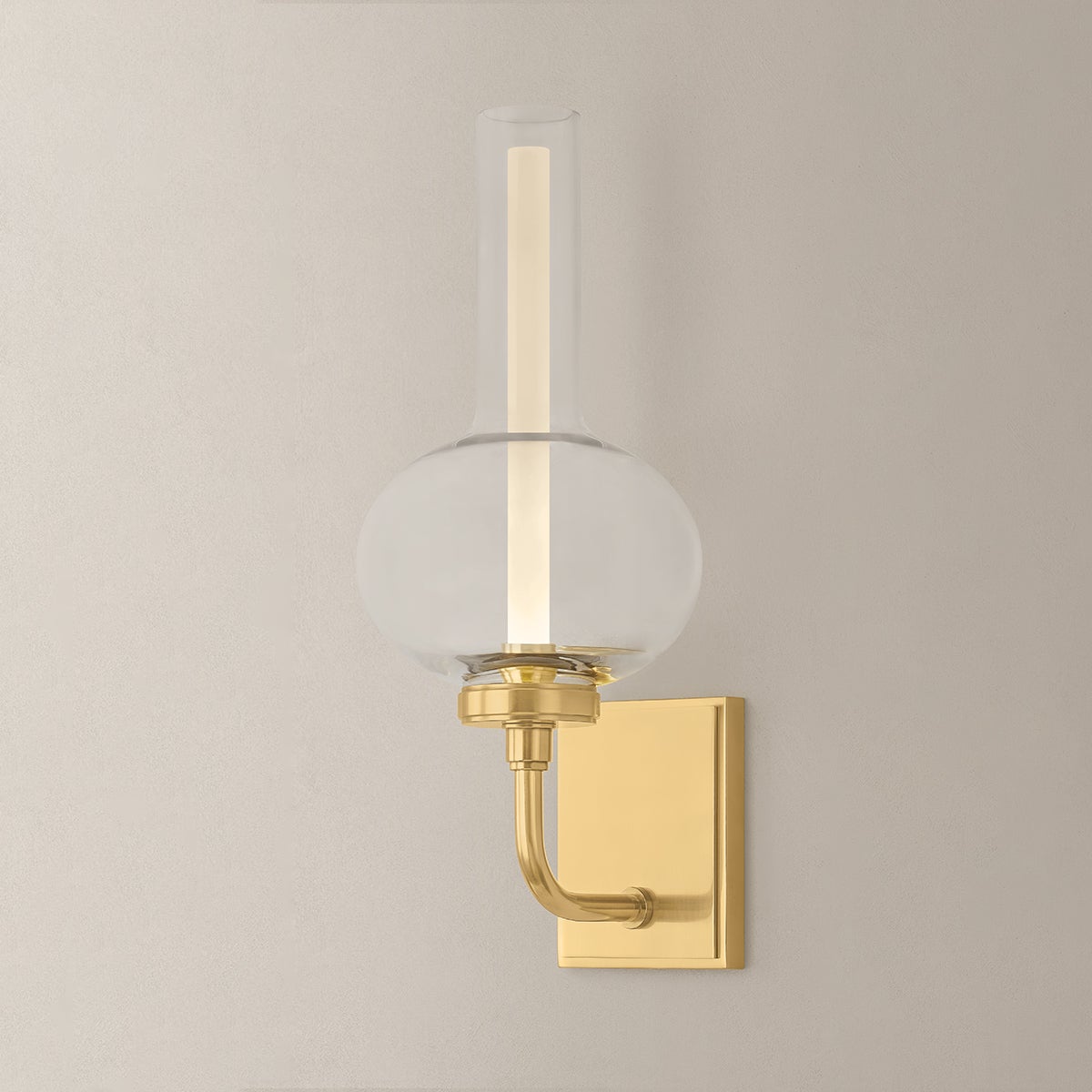 Close-up of the Rossman Wall Sconce in aged brass showing the arm curve and shade silhouette.