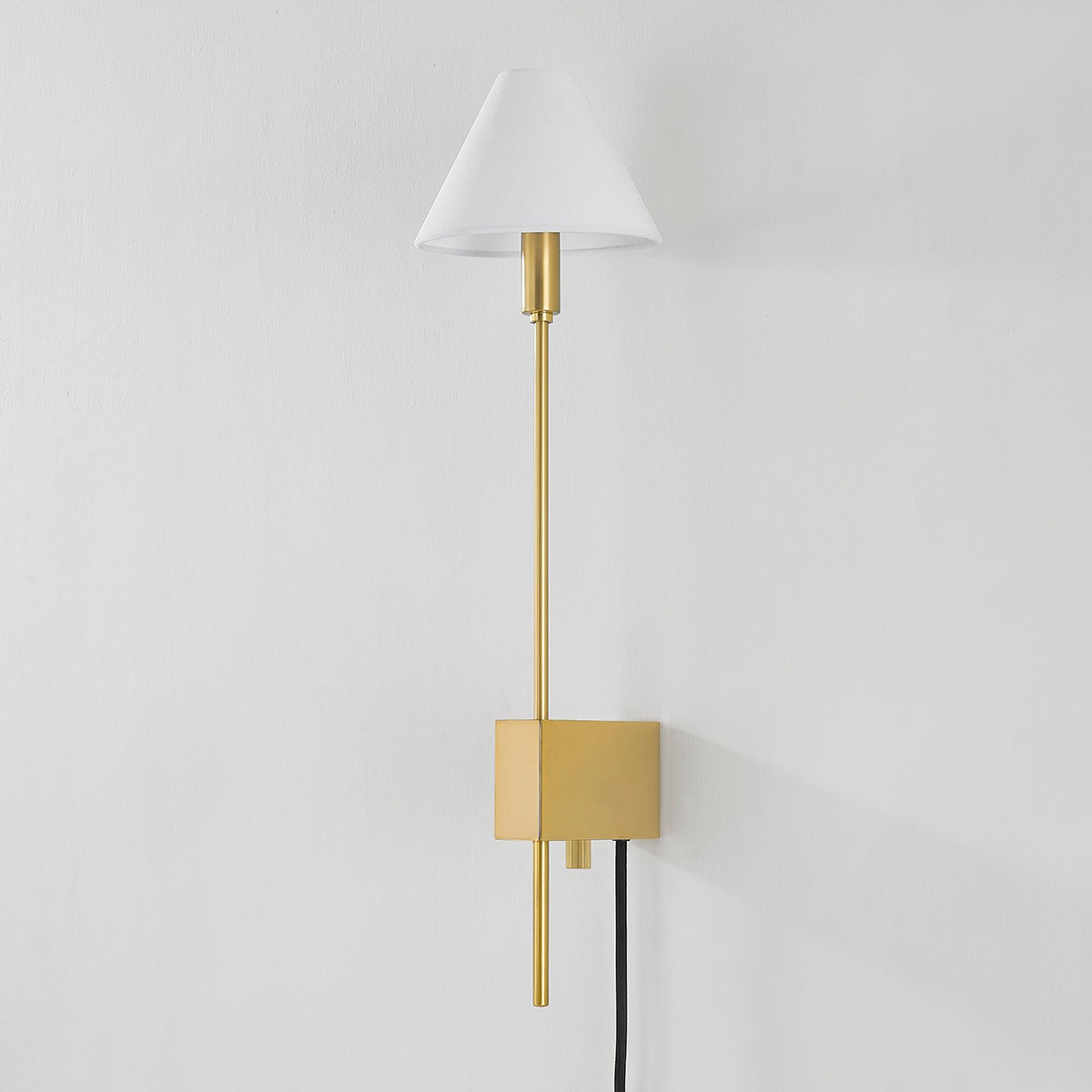Teaneck Plug-In Sconce in aged brass shown from the front to reveal the arm profile and shade silhouette.