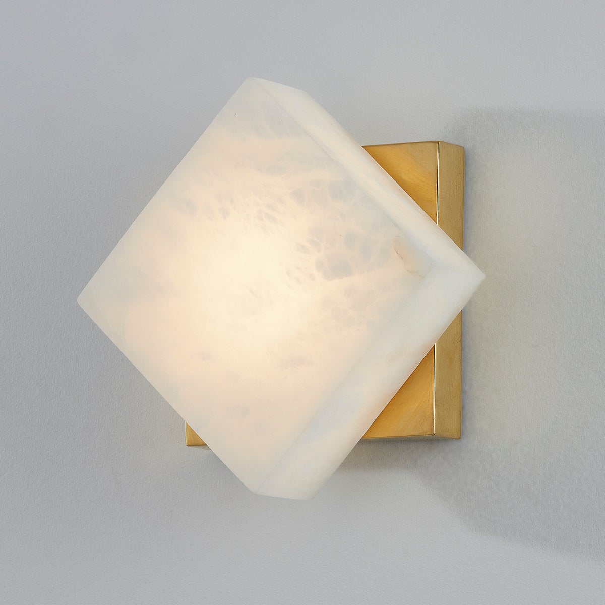 Brockton Wall Sconce in aged brass shown from the front to reveal the arm curve and shade silhouette.