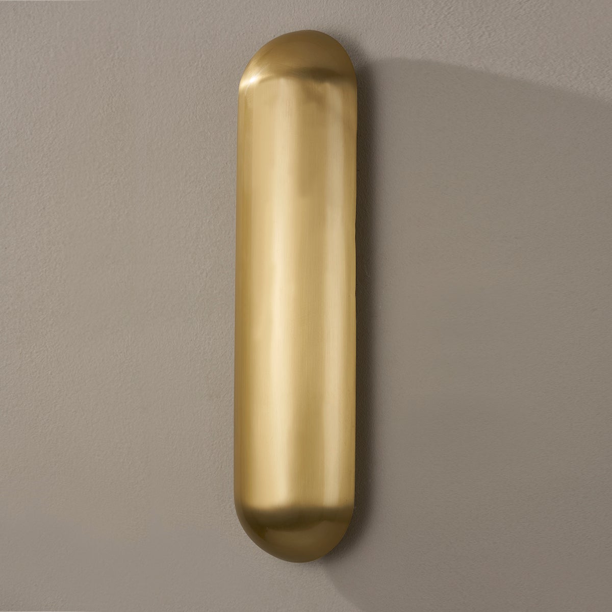Wheeler Wall Sconce in aged brass shown from the front to reveal the arm curve and shade silhouette.