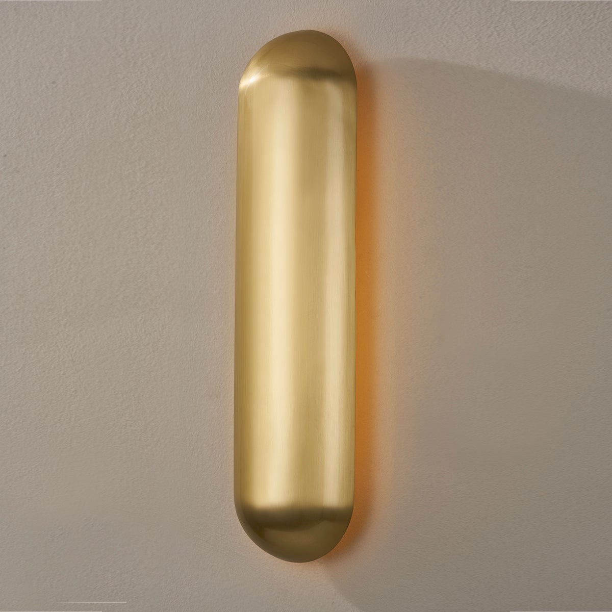 Close-up of the Wheeler Wall Sconce in aged brass showing the arm curve and shade silhouette.