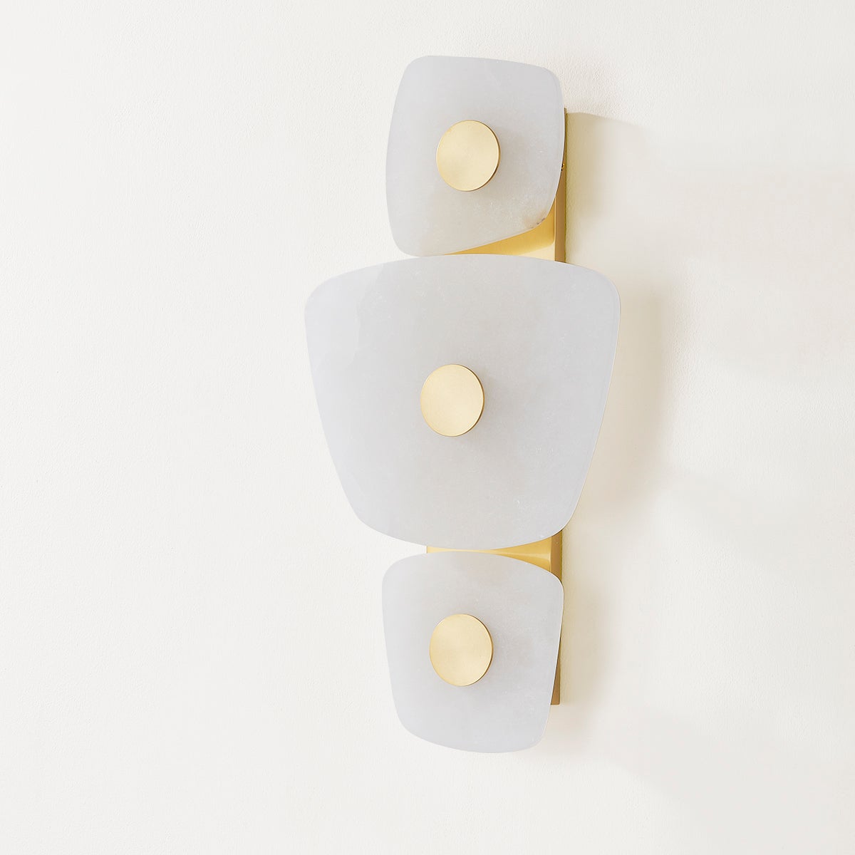 Holmdel Wall Sconce in aged brass shown from the front to reveal the arm curve and shade silhouette.