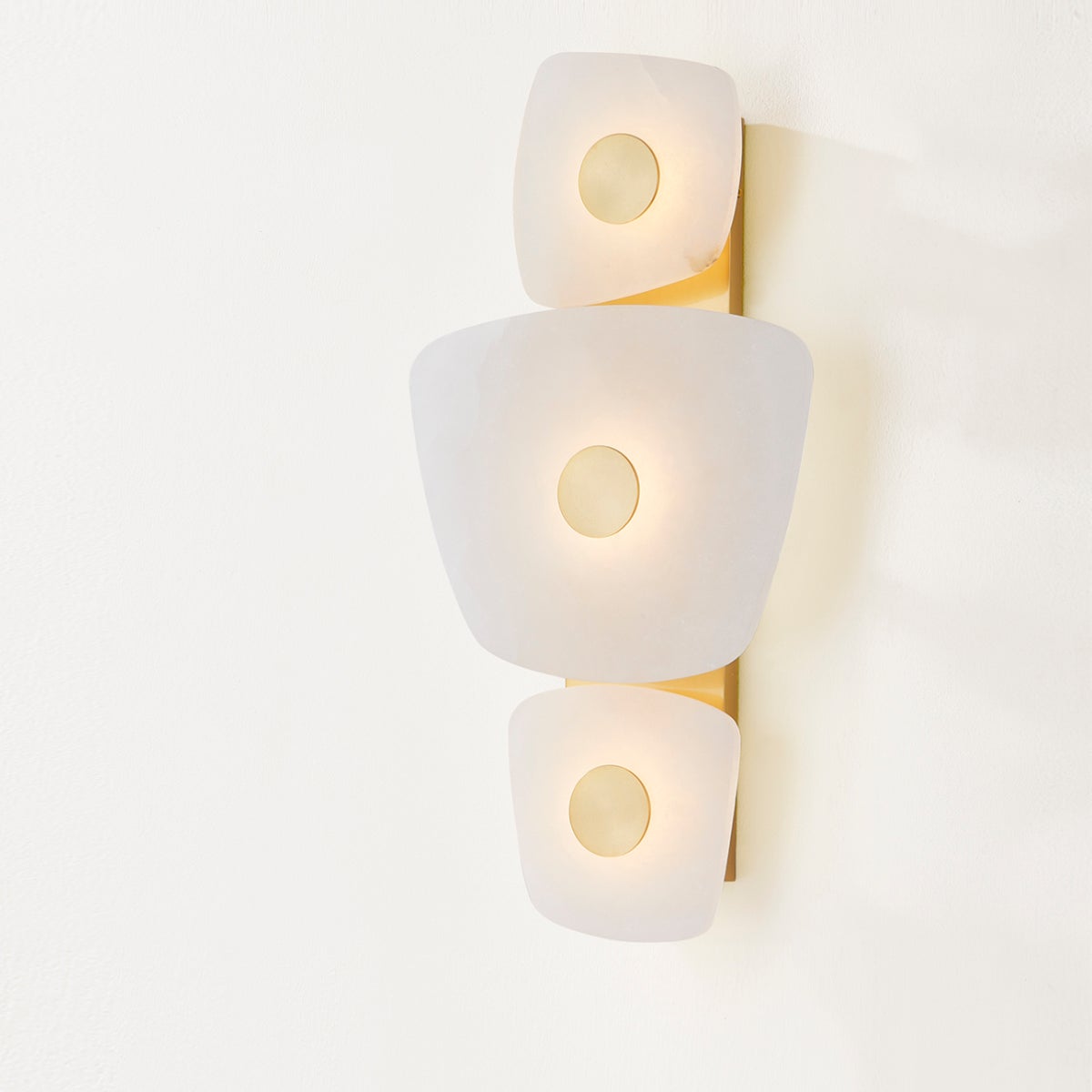 Close-up of the Holmdel Wall Sconce in aged brass showing the arm curve and shade silhouette.