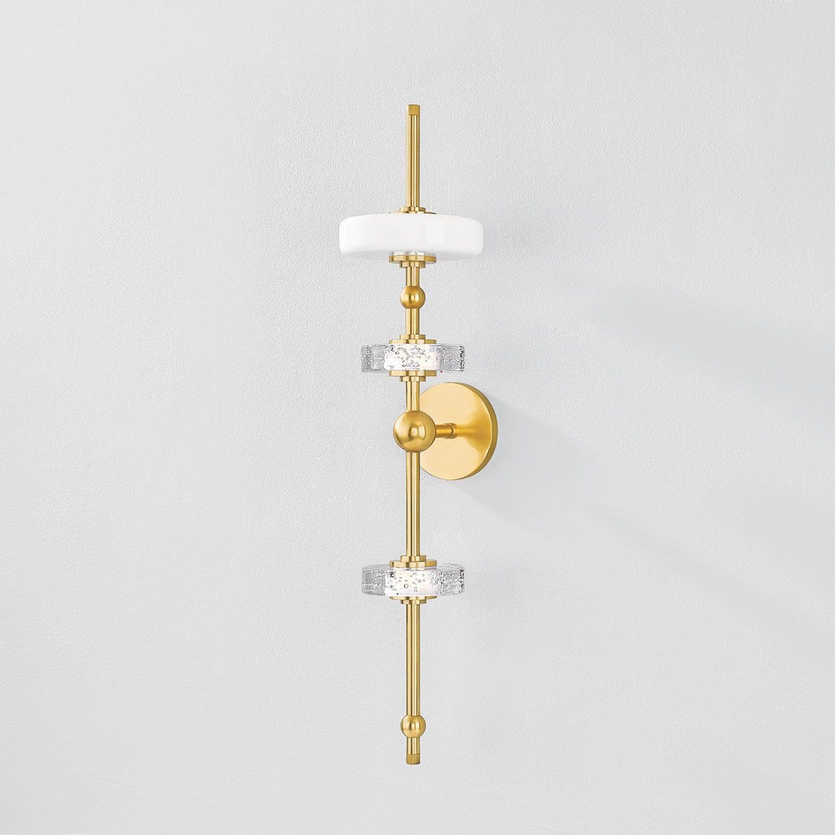 Maynard Wall Sconce in aged brass shown from the front to reveal the arm curve and shade silhouette.
