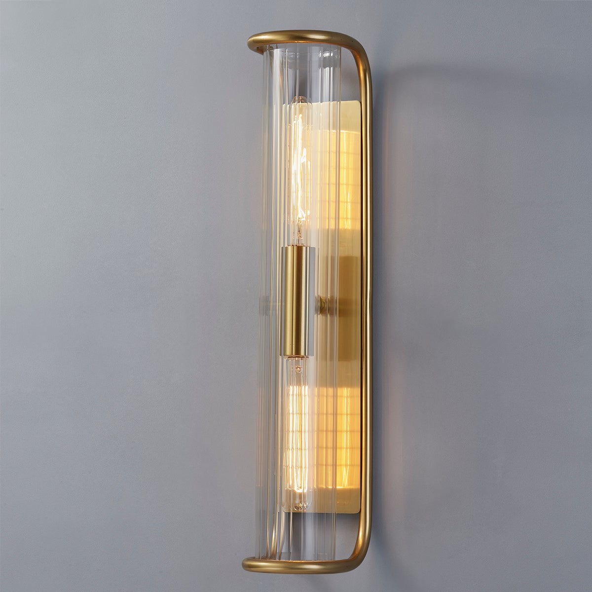 Fillmore Wall Sconce 5.5" x 26.25" in aged brass shown from the front to reveal the arm curve and shade silhouette.