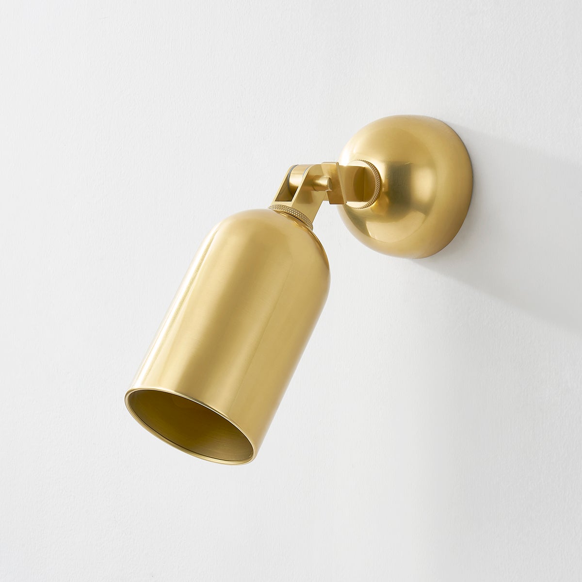 Sturbridge Wall Sconce in aged brass shown from the front to reveal the arm curve and shade silhouette.