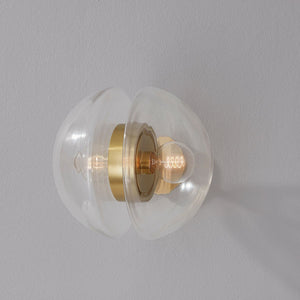 Close-up of the Kert Wall Sconce in aged brass showing the arm curve and shade silhouette.