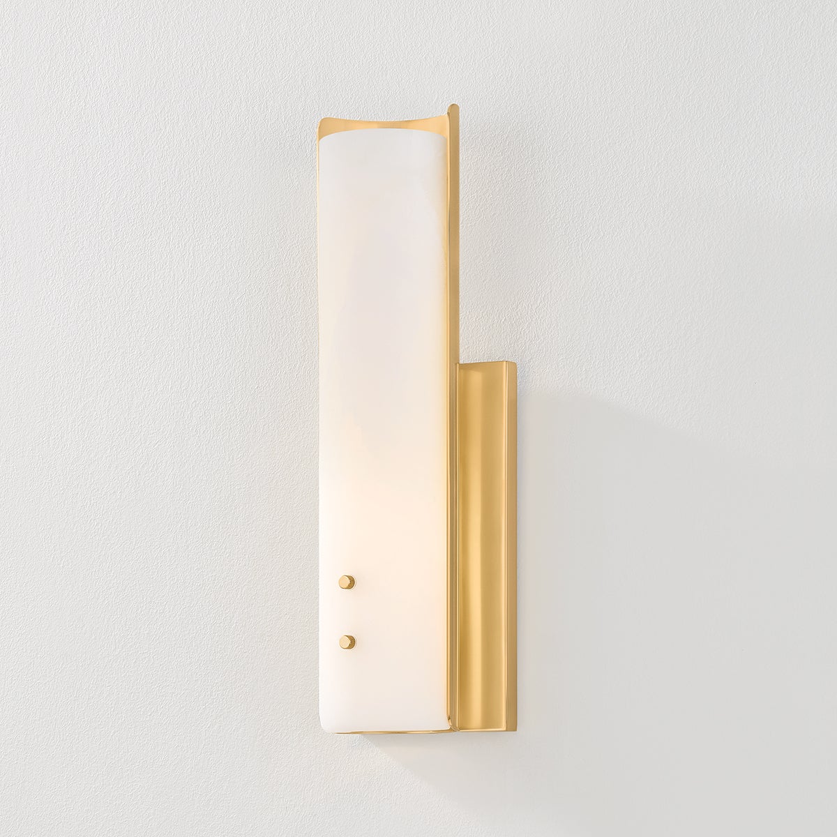 Close-up of the Lucio Wall Sconce 4.25" x 14.5" in aged brass showing the arm curve and shade silhouette.