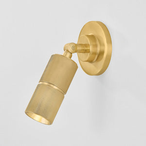 Close-up of the Truett Wall Sconce in aged brass showing the arm curve and shade silhouette.
