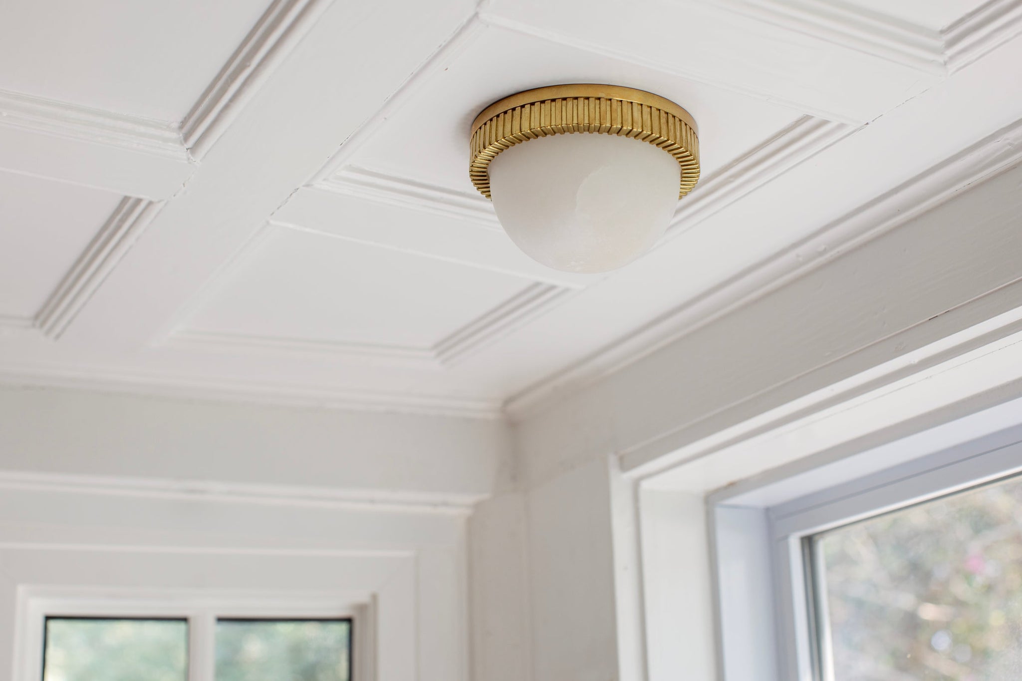 Ainsley Flush Mount in aged brass styled in a bedroom for warm, layered light at Laurie Yapp Home.