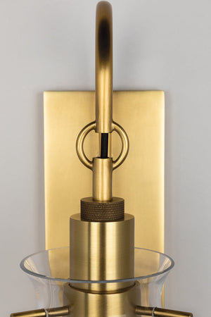 Close-up of the Ivy Wall Sconce in aged brass showing the arm curve and shade silhouette.