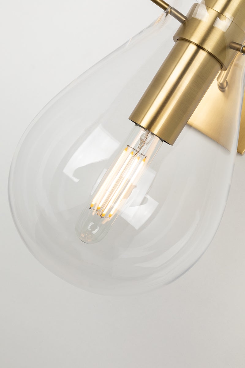 Close-up of the Ivy Wall Sconce in aged brass showing the arm curve and shade silhouette.