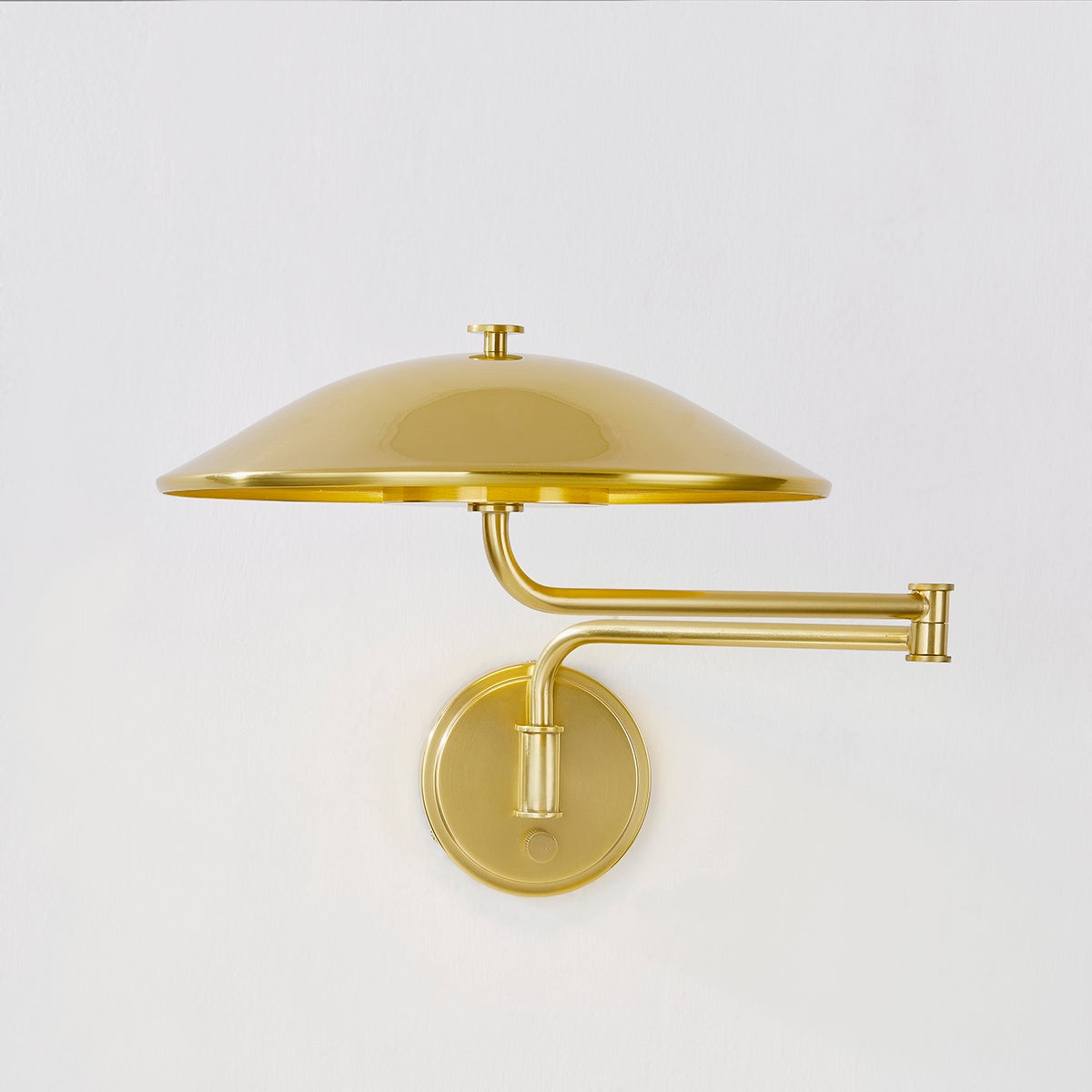 Brockville Wall Sconce in aged brass shown from the front to reveal the arm curve and shade silhouette.