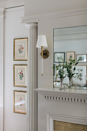 Blixen Wall Sconce in aged brass styled in a warmly lit hallway for warm, layered light at Laurie Yapp Home.