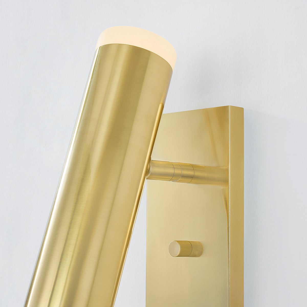 Close-up of the Clark Wall Sconce in aged brass showing the arm curve and shade silhouette.