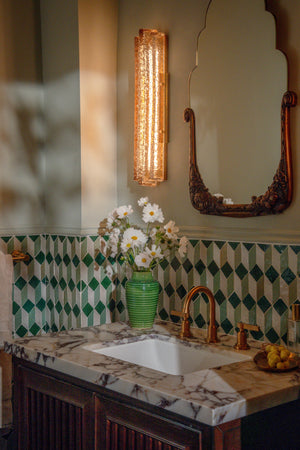 Carnelian Wall Sconce styled in a modern bathroom for warm, layered light at Laurie Yapp Home.