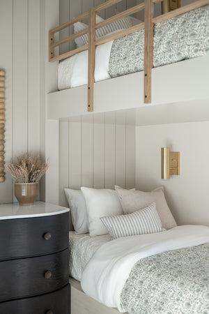 Clark Wall Sconce in aged brass styled in a warmly lit hallway for warm, layered light at Laurie Yapp Home.