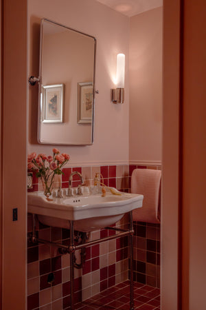 Colrain Wall Sconce 5.25" x 17.5" in polished nickel styled in a modern bathroom for warm, layered light at Laurie Yapp Home.