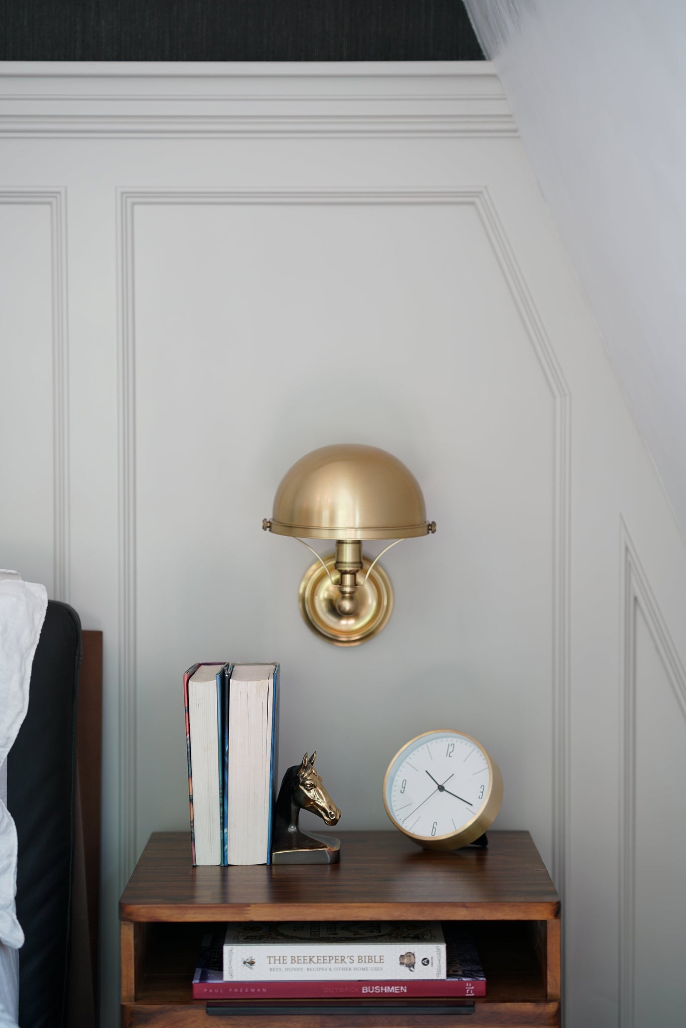 Close-up of the Covington Wall Sconce in aged brass showing the arm curve and shade silhouette.
