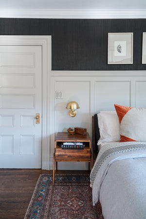 Close-up of the Covington Wall Sconce in aged brass showing the arm curve and shade silhouette.