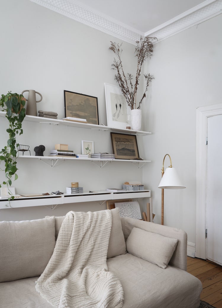 Curves No.1 Floor Lamp in aged brass styled in a living room corner for warm, layered light at Laurie Yapp Home.