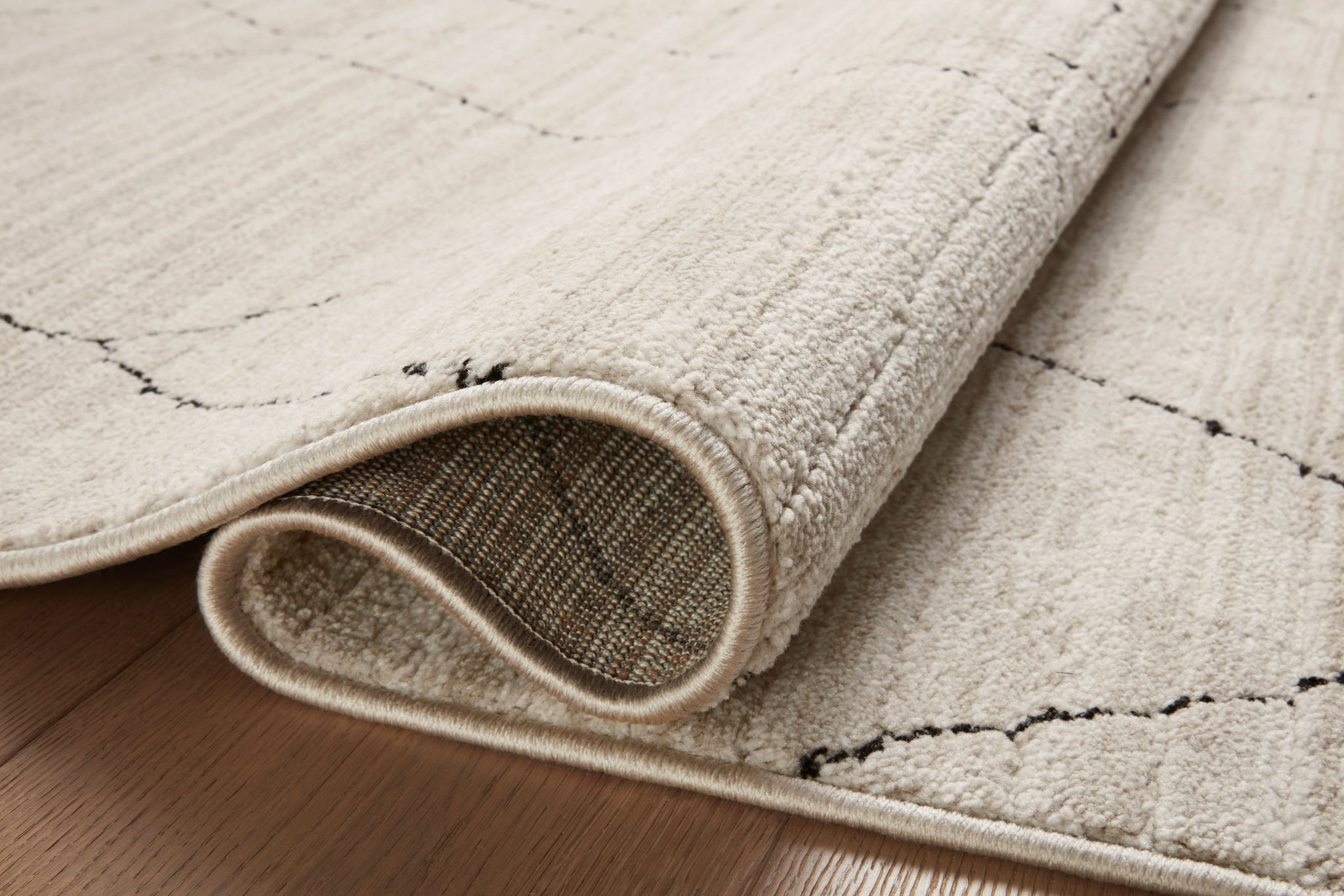Close-up detail of the Darby Sand / Charcoal showing its pile and weave.
