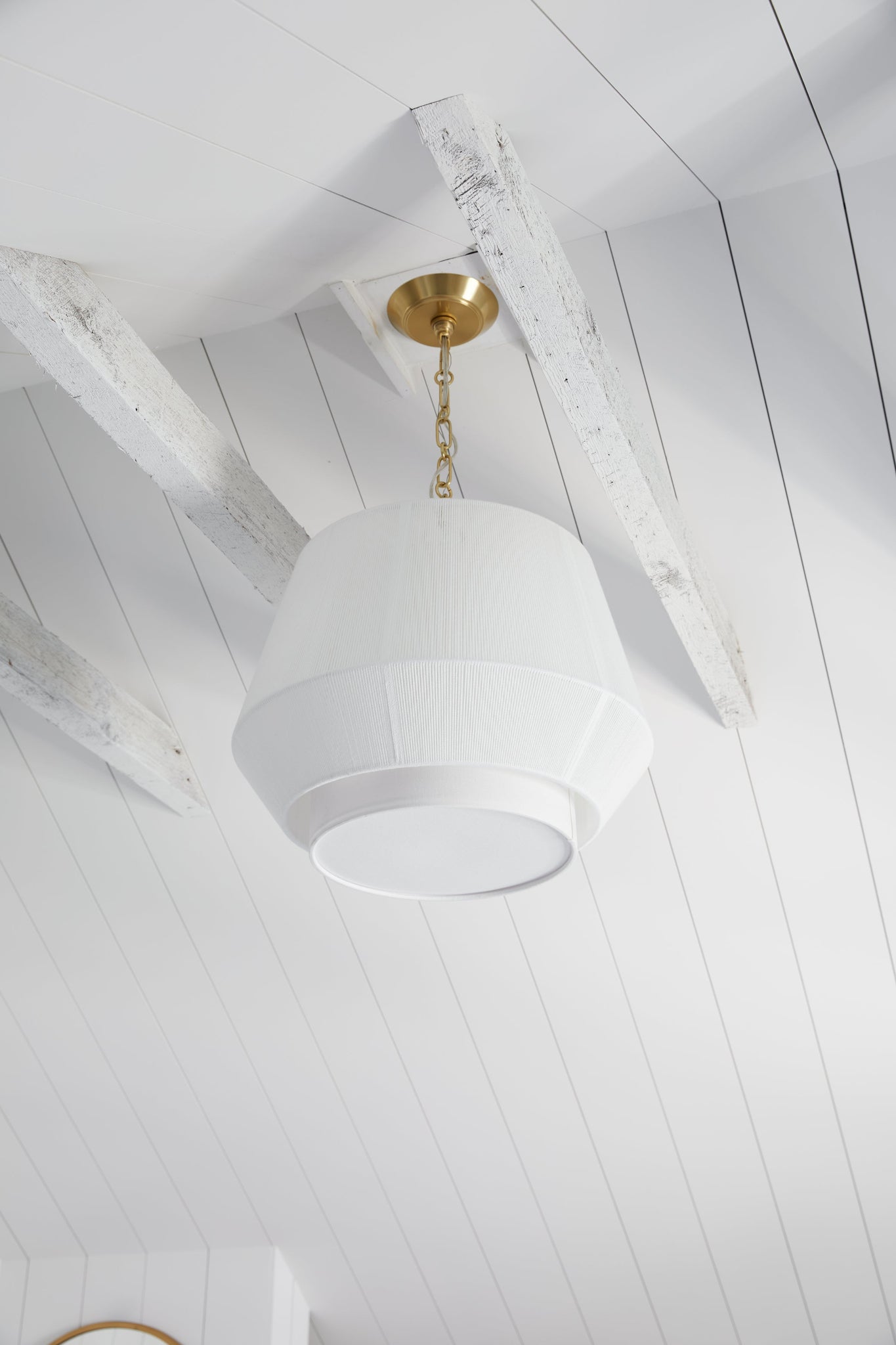 Debi Pendant 18" in aged brass styled in a welcoming entryway for warm, layered light at Laurie Yapp Home.