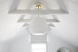 Debi Pendant 18" in aged brass styled in a welcoming entryway for warm, layered light at Laurie Yapp Home.