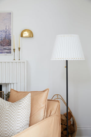 Diggs Wall Sconce in aged brass styled in a modern bathroom for warm, layered light at Laurie Yapp Home.
