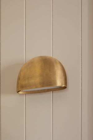 Diggs Wall Sconce in aged brass styled in a curated living room for warm, layered light at Laurie Yapp Home.
