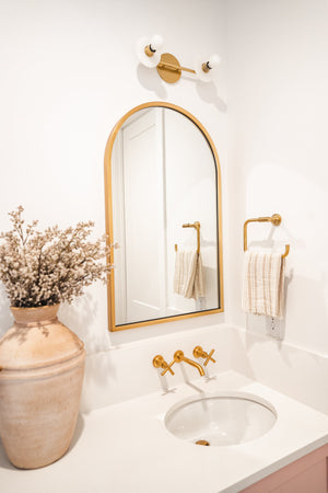 Elmont Bath And Vanity 4.75" x 15.5" in aged brass styled in a powder room for warm, layered light at Laurie Yapp Home.