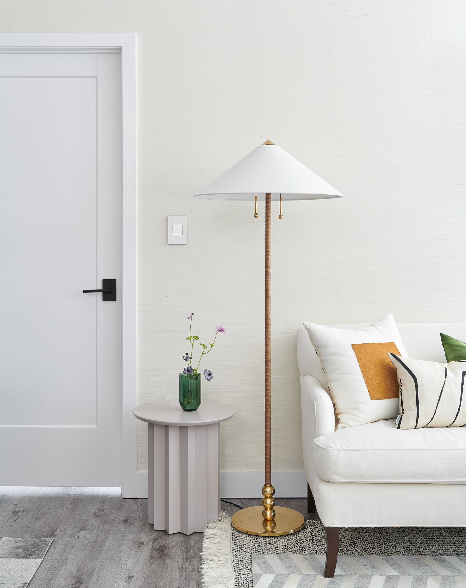 Flare Floor Lamp in aged brass styled in a living room corner for warm, layered light at Laurie Yapp Home.