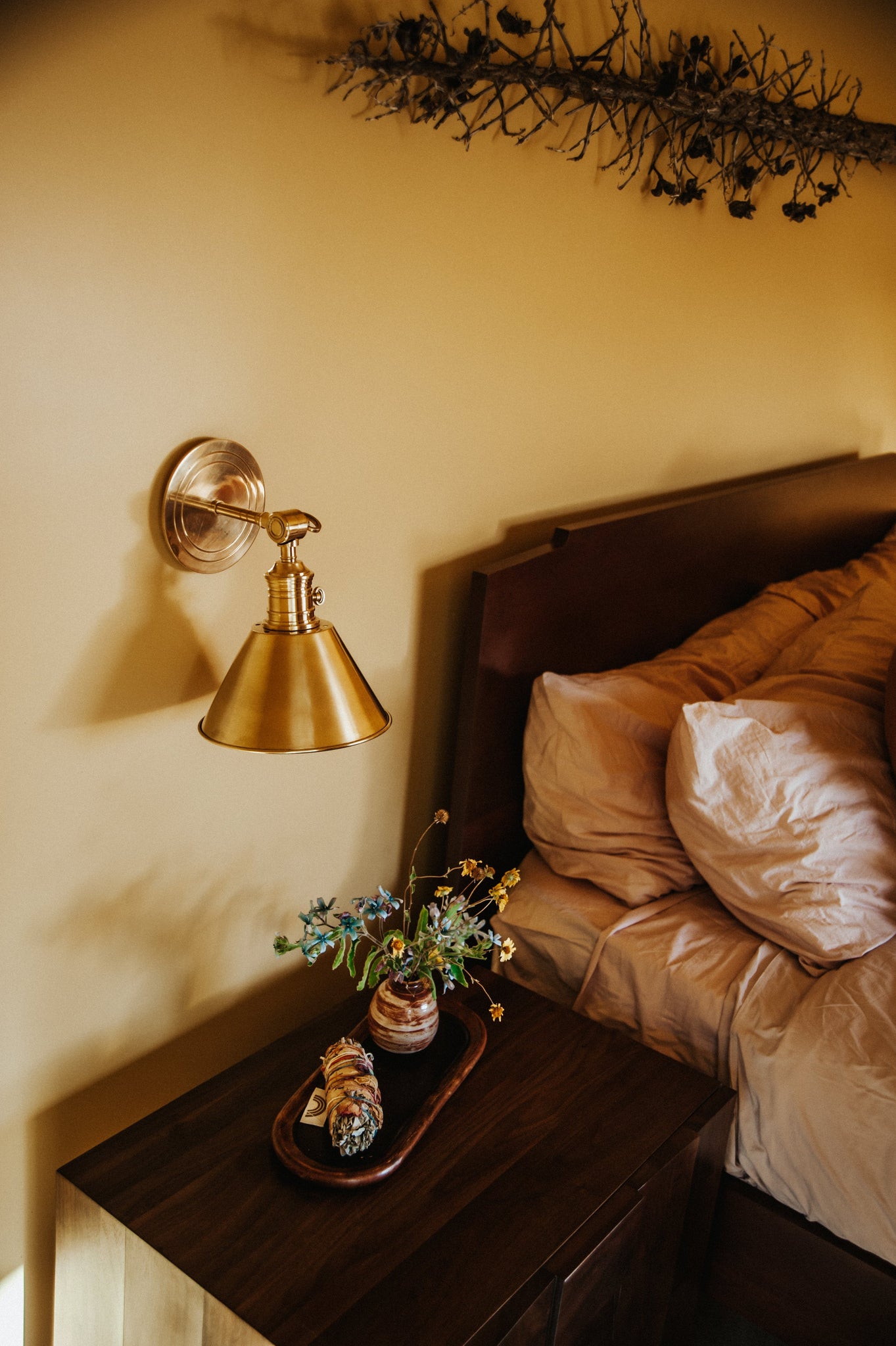 Close-up of the Garden City Wall Sconce 8" x 11" in aged brass showing the arm curve and shade silhouette.